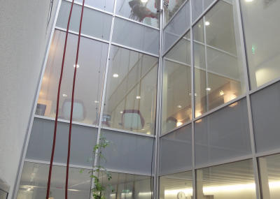 Industriekletterer bei Glasreinigung am hängenden Seil, Arbeit am Seil in Lichtschacht