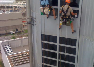 Industriekletterer bei Glasreinigung am hängenden Seil, Arbeit in der Höhe