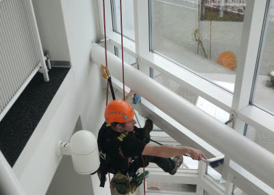 Industriekletterer bei Glasreinigung am hängenden Seil, Arbeit am Seil